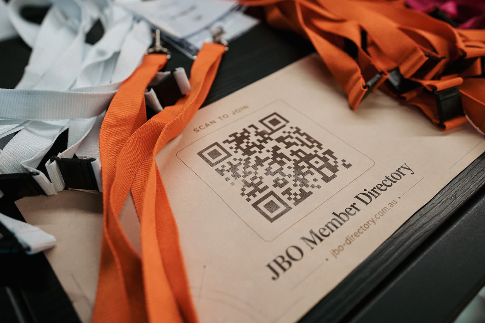 The printed JBO Member Directory card with its scan-to-join QR code, on the welcome table