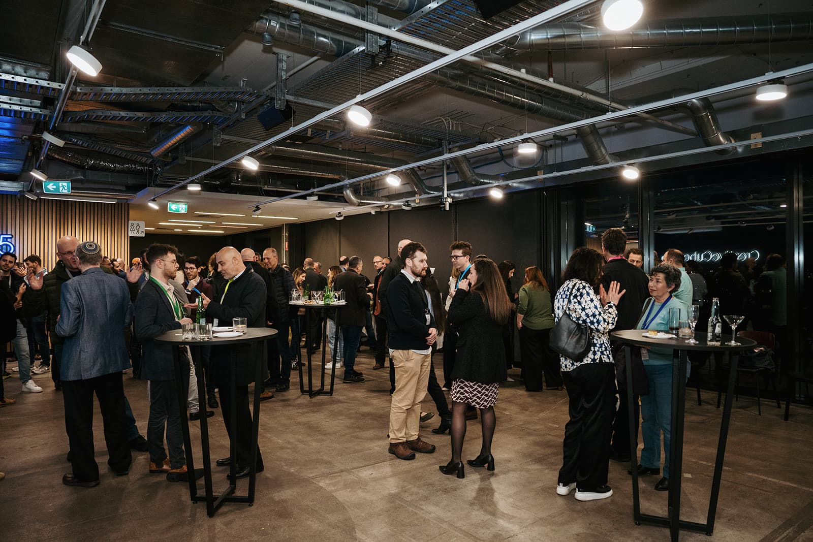 JBO members talking in small groups around high tables at the first JBO event in Melbourne
